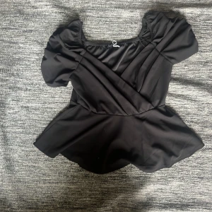 Så söt svart blus perfekt till hösten - Så söt svart blus som är perfekt till hösten. Helt oanvänd och säljer då den är för stor. Vluseb är från fashion Nova. Det står ingen storlek men skulle säga att den är medium till large