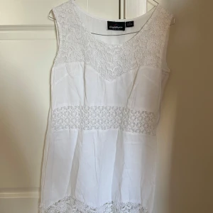 Vit ärmlös topp från Clara Roux - Säljer en superfin vit ärmlös topp från Clara Roux. Den har vackra spetsdetaljer på bröstet och längs nederkanten som ger en romantisk touch. Perfekt för sommardagar eller en avslappnad fest. Toppen är i mycket bra skick och passar till både jeans och kjol.