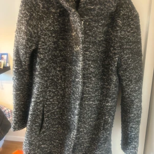 Grå kappa från ONLY - Säljer en supermysig grå kappa från ONLY i storlek S. Den är perfekt för höst och vinter med sitt tjocka, stickade material. Kappan har en hög krage och långa ärmar, vilket gör den både stilren och varm. Perfekt för att hålla stilen i kyligare väder!