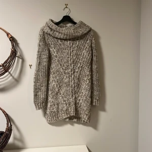 Beige stickad tröja från H&M - Mysig beige stickad tröja från H&M i storlek XS. Perfekt för kyliga dagar med sin långa passform och stora polokrage. Tröjan har ett snyggt flätmönster och är superbekväm att ha på sig. Passar perfekt till både vardag och mysiga hemmakvällar. Inga defekter💞