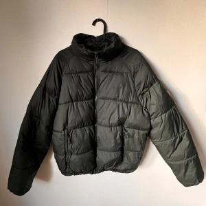 Svart pufferjacka från Zara - Säljer en svart pufferjacka från Zara i storlek L. Jackan är perfekt för kalla dagar med sitt quiltade mönster och dragkedja framtill. Den har en hög krage för extra värme och är i mycket bra skick. Perfekt för både höst och vinter!