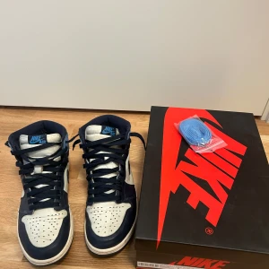Nike Air Jordan 1 High Obsidian - Säljer ett par Nike Air Jordans 1 High Obsidian. Skorna har en klassisk design med snörning och hög ankel. De är i mycket bra skick och kommer med originalkartong och extra skosnören i blått. Storlek 41 (svårt att hitta i detta skick), kvitto finns. Perfekta för både vardag och speciella tillfällen! Tveka inte att höra av er! 