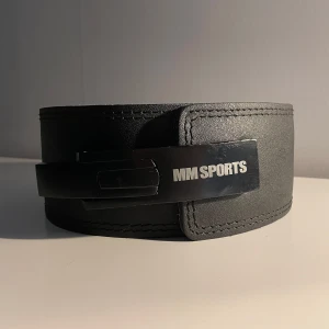 Svart gymbälte från MM Sports - Säljer ett svart gymbälte från MM Sports i bra skick. Bra för tunga lyft och ger bra stabilitet. Inner sömmen har släppt lite men ger ingen försämrad funktion, nypris 600 kr. Storleken är justerbar med hjälp av skruvmejsel, se bild 4.
