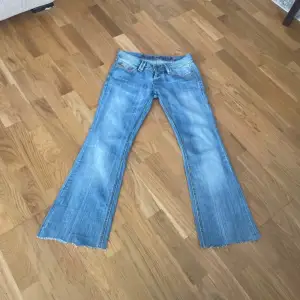 Säljer ett par snygga lågmidjade bootcut jeans ifrån JustPlay, de är en ljusblå färg med en jättefin tvätt! innerben: 77 cm.   midja: 36 cm.   midjehöjd: 19 cm.   De är klippta