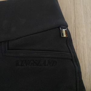 Svarta ridbyxor från Kingsland - Säljer ett par svarta/mörkgrå ridbyxor från Kingsland i storlek 36. Inte använda så mycket och i bra skick.