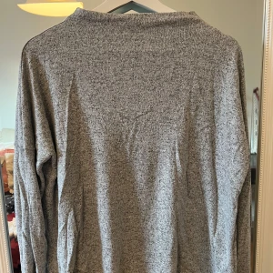 Grå långärmad tröja - Säljer en enkel och stilren grå långärmad tröja. Perfekt för vardagsbruk och passar till det mesta. Tröjan är i bra skick och har en mjuk och bekväm känsla. Perfekt för höst och vår!