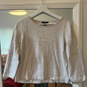 Grå tröja med armbågslappar från H&M - Säljer en stilren grå tröja från H&M i bomull. Den har trekvartsärmar och snygga bruna armbågslappar som ger en cool touch. Perfekt för både vardag och lite mer avslappnade tillfällen. Passar bra till jeans eller kjol!