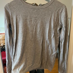 Grå tröja med dragkedja - Säljer en stilren grå tröja i bra skick. Den har en praktisk dragkedja i ryggen och är långärmad. Perfekt för både vardag och lite kyligare dagar. Passar till det mesta i garderoben!