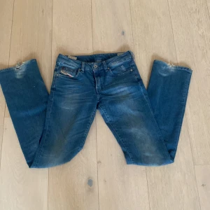 Blå jeans från Diesel - Säljer ett par snygga blå jeans från Diesel i modellen Ronhar, L32 W26, passar mig som är 170 lite långa där med slitna vid marken, och därmed också ett lägre pris!!