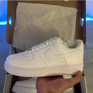  Air Force 1 - Säljer ett par klassiska vita Nike Air Force 1 i nytt skick. De är helt vita med snörning och har den ikoniska Nike-loggan på sidan och hälen. Perfekta för alla tillfällen och ger en stilren look. Skorna är i storlek herr 43. Passar till både tjejer och killar. Priset är inte hugget i sten, kontakta vid frågor.