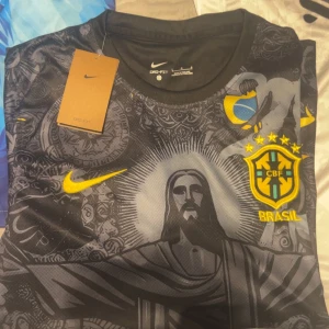 Fotbollströjor  - Säljer en svart Real Madrid tröja med snyggt blommönster och Y-3 design. Den har vit text med 'Emirates Fly Better' och klubbens emblem. Perfekt för fans som vill ha något unikt och stilrent! 🖤
