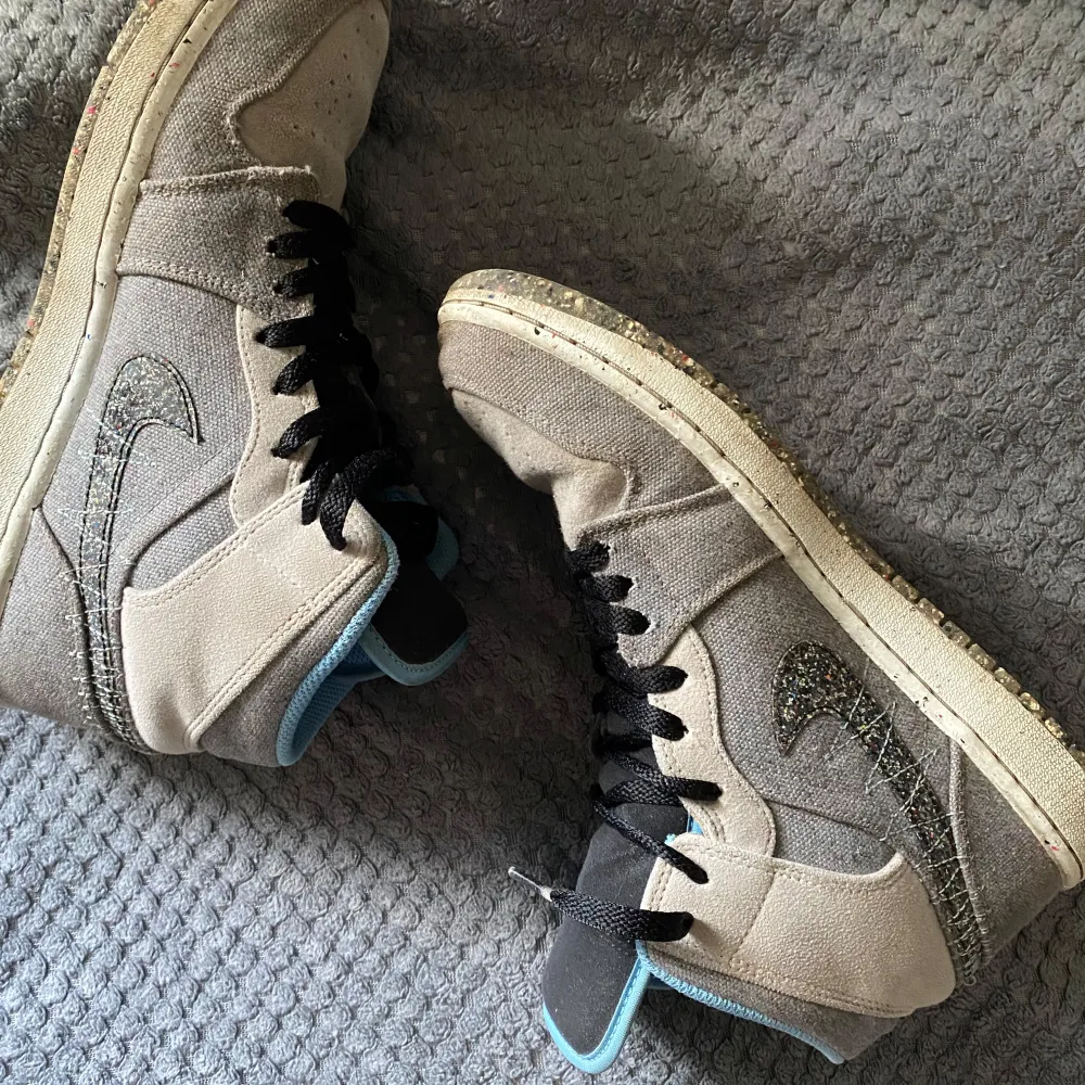Säljer ett par grå Nike Air sneakers i bra skick. De har snygga blå detaljer och svart snörning. Perfekta för vardagsbruk eller träning. Skorna har en cool design med det klassiska Nike-märket på sidan.. Kengät.