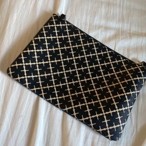 Svart och beige kuvertväska med mönster - Snygg kuvertväska från malene birger som inte längre kommer till användning. Perfekt för en utekväll eller till skolan.Väskan har en dragkedja upptill för säker förvaring av ens saker❤️🥰Skriv för mer frågor!