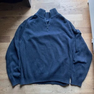 Mörkblå half-zip tröja från Henri Lloyd - Säljer en snygg mörkblå tröja från Henri Lloyd i storlek L. Tröjan är stickad och har en dragkedja vid halsen för en stilren look. Perfekt för både höst och vinter, och den är gjord av bomull vilket gör den bekväm och varm. Passar bra till jeans för en avslappnad stil.