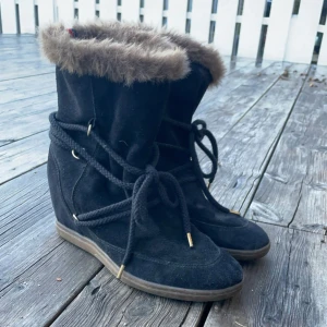 Svarta boots med klack och pälsdetalj - Snygga svarta boots i mocka med mysig pälsdetalj runt skaftet från Tommy Hilfinger med snörning framtill för en perfekt passform. Perfekta för hösten och vintern🩷