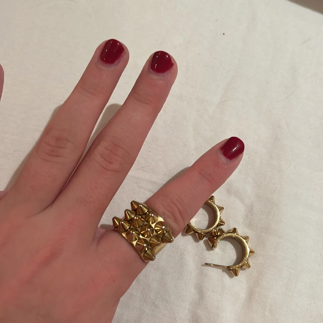 Guldiga örhängen och ring med nitar - 91