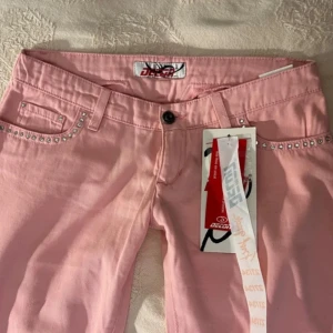 Extremt lågmidjade byxor  - Rosa byxor med extremt låg midja. W27/L34, nya med prislapp kvar 