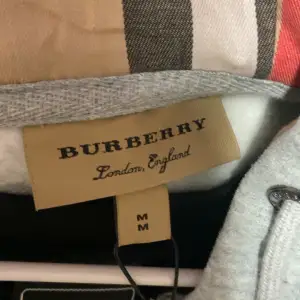 Säljer en snygg grå hoodie från Burberry i storlek M. Den har dragkedja och en liten logga på bröstet. Perfekt för både vardag och chill. Huvan och de långa ärmarna gör den extra mysig. Passar perfekt till höst och vår!