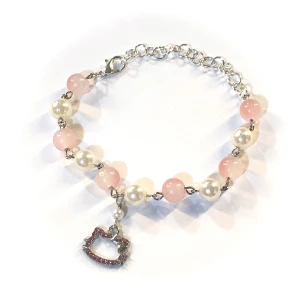 Sött hello kitty armband med pärlor  - Detta armband är supergulligt med vita pärlor och rosa pärlor som ger en fin kontrast. Det har en charmig hängande berlock i form av ett hjärta. Perfekt för att lägga till en söt touch till din outfit!