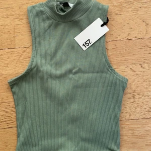 Grönt ribbad linne - Säljer en snygg grön ribbad topp från 157 i nytt skick med prislapp kvar. 
