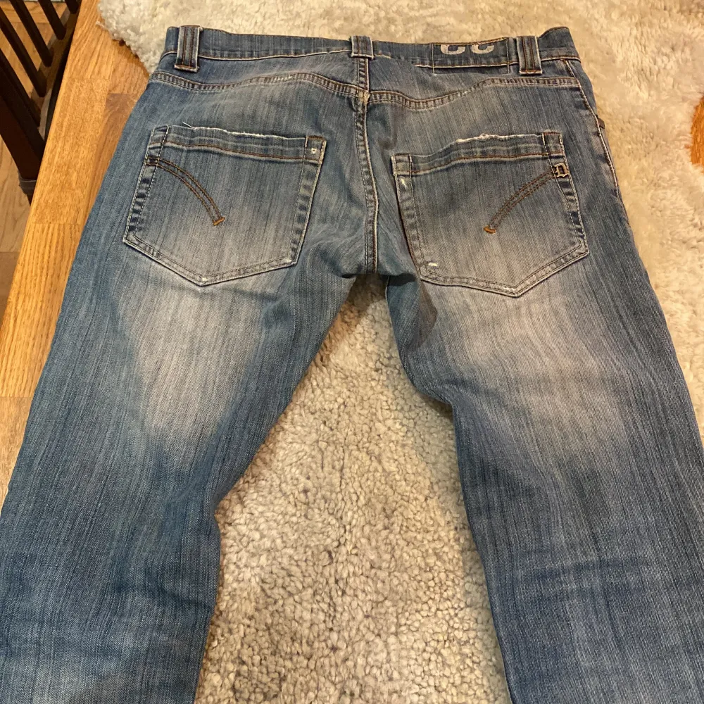 Säljer ett par snygga blå jeans från Dondup i storlek 32. De har en cool slitning på ena benet och klassiska femficksdesign. Jeansen har en knappgylf och är i bra skick. Perfekta för en avslappnad stil nu till vintern!❄️. Jeans & Byxor.