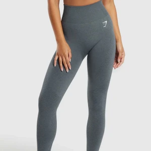 Grå leggings från Gymshark - Säljer ett par grå leggings från Gymshark i mycket bra skick. De är högmidjade och har en tight passform, perfekt för träning. Materialet är stretchigt och bekvämt, vilket gör dem idealiska för både gymmet och yoga. Diskret logga på höften.