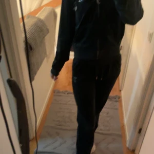 Mörkgröna mjukisbyxor och hoodie från Juicy Couture - Säljer ett set med mörkgröna mjukisbyxor och matchande hoodie från Juicy Couture eftersom dom används inte längre. Säljer både byxor o hoodien tillsammans. Byxorna har snörning i midjan och en broderad logga. Hoodien har dragkedja och känguruficka, också med broderad logga. Perfekt för mysiga dagar hemma eller en avslappnad stil ute. Priset kan diskuteras vid snabb äfär