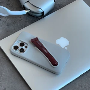 Grått mobilskal med röd detalj - Mobilskal med läppglanshållare 💄 iPhone 13/14/15 pro