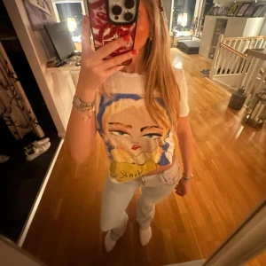 Vit t-shirt med tryck - Säljer en vit t-shirt med ett coolt  tryck av en kvinna och texten newyork. T-shirten har korta ärmar och är i normal passform med en hel vit rygg. Tröjan gör att styla på flera olika sätt som ett ex vika upp den lite som jag gjort eller vända på den och ha trycket i ryggen utan att tröjan ser konstig ut! Säljes då jag tyvärr inte fått så mycket användning av den. Bara att skriva vid frågor osv🤍🩵 ( Str xs/s )