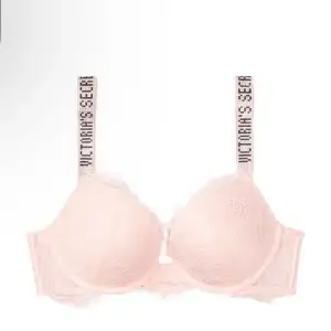 Snygg och feminin rosa BH från Victoria's Secret med spetsdetaljer. Axelbanden har märkets logga i svart text. Perfekt för en touch av lyx i vardagen. Har en lite deflekt på axelbandena fast inget som märks!