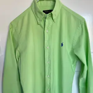 Ljusgrön/Mintgrön oxfordskjorta från Polo Ralph Lauren. Storlek: S - Slim fit. I mycket bra skick. Finns en väldigt liten fläck som säkert går att fä bort om man är petig (sista bilden). 