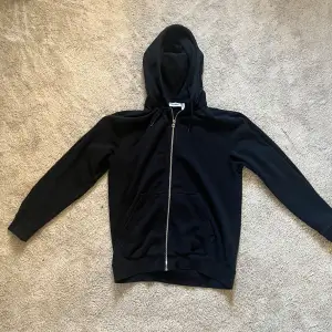 Säljer en snygg svart zip hoodie från weekday. Använd max 5 gånger så i väldigt fint skick. 