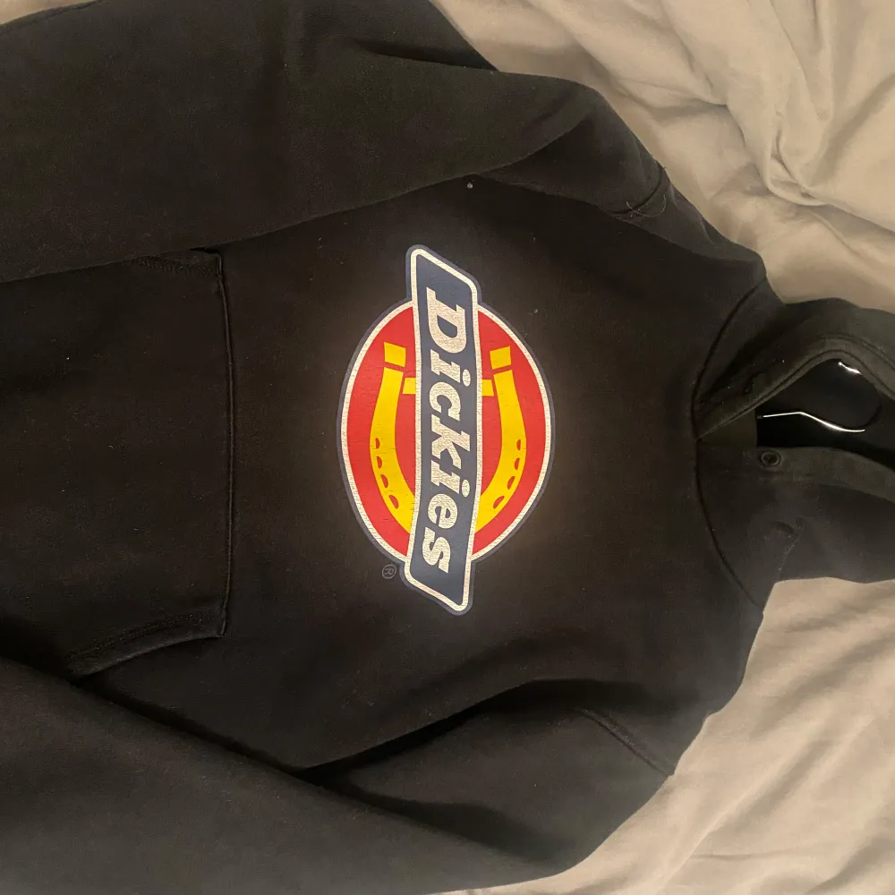 Säljer en svart hoodie från Dickies i storlek S. Den har det klassiska Dickies-loggan i rött, gult och vitt på framsidan. Perfekt för en casual look och superbekväm att ha på sig. Passar bra till både höst och vinter. Hör av dig om du är intresserad! 🖤. Tröjor & Koftor.