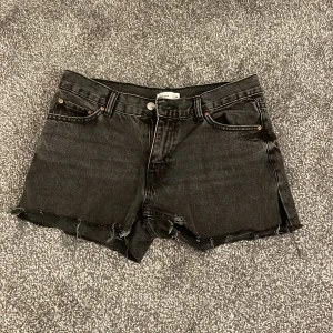 Svarta jeansshorts från Gina tricot - Snygga svarta jeansshorts från Gina tricot med råa kanter och klassisk femficksdesign. Perfekta för en sommardag. Mycket snygga på! 