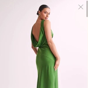 Grön långklänning Meshki - Populär otroligt snygg grön långklänning i satin med djup v-ringning och öppen rygg från Meshki. Säljer den eftersom den tyvärr inte passade mig. Helt perfekt till Balen eller bröllop. Aldrig använd bara provad💕