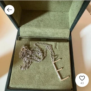 Silverfärgat halsband med bokstavshänge - Säljer nu mitt E halsband från maria nilsdotter eftersom jag vill byta till guld smycken, lånad bild skriv för egna bilder