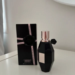 Flowerbomb Midnight EdP 50ml - Säljer en elegant Flowerbomb Midnight Eau de Parfum från Viktor & Rolf. Flaskan är svart och facetterad med en stilren design och silverfärgad kork. Perfekt för den som älskar en mystisk och blommig doft.