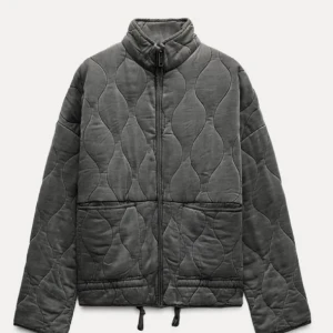 Grå quiltad jacka zara - Snygg grå quiltad jacka med dragkedja och hög krage. Jackan har en modern design med vågformade quiltmönster och praktiska fickor framtill. Perfekt för kyligare dagar.