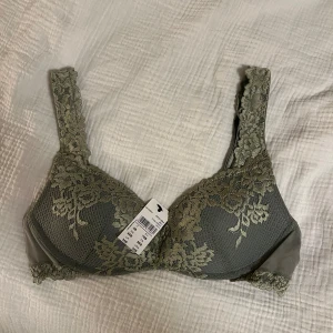 Grön spets-bh från Intimissimi  - Säljer en grön bh från Intimissimi med spetsdetaljering. Färgen är fade green, sök upp den färgen då bilderna inte visar riktigt. Det är modellen Gioia, med pushup. 