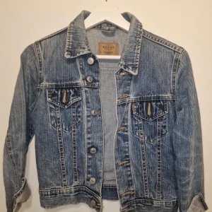 Blå jeansjacka från Rocky - Snygg blå jeansjacka från Rocky med klassisk krage och knappar framtill. Garderobsrensning så kika gärna på övriga auktioner.