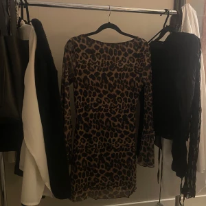Leopardmönstrad klänning med öppen rygg - Snygg leopardmönstrad klänning med långärmad design och en öppen rygg.🐆