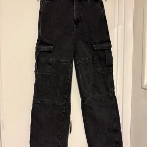 Svarta cargobyxor - Säljer ett par svarta cargobyxor med flera praktiska fickor. Byxorna har en loose passform och är perfekta för en avslappnad stil. De är högmidjade och tillverkade i ett slitstarkt material.