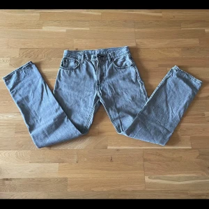 Grå Levis 551 jeans - Säljer ett par klassiska grå Levis 551 jeans. De har en straight passform och är tillverkade i slitstarkt denim. Perfekta för en avslappnad stil. Midjan är midwaist och de har den ikoniska Levis-lappen baktill. Storleken, W30 L34