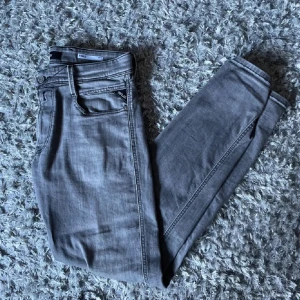 Replay jeans - Snygga grå jeans från Replay medel anbass. Är stilrena och med en snygg och skön passa form. Finns en liten difekt som man inte ser vid användning. Priset går att diskutera vid snabb affär.