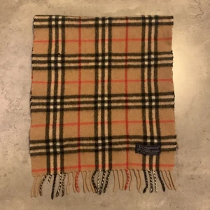 Burberry halstuk - Säljer helt äkta burberry halstuk det finns ett pyttelitet hål men det är nåt man inte ser annars är den helt perfekt jag säljer för jag inte använder