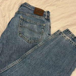 Blå jeans från Lee - Säljer ett par klassiska blå jeans från Lee med relaxed fit. De har en dragkedja och knapp framtill samt en bakficka med Lee-logga. Perfekta för en avslappnad stil. W29L30