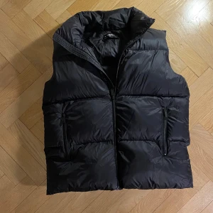 Dsquared2 väst - Dsquared2 väst i nyskick säljes! Svart, stilren design och äkta. Storlek: 14y men passar xs/xxs. Endast använd ett fåtal gånger. Ett kap för den som vill ha lyx till bra pris! Kontakta för mer info. Nypris ca 4000kr. Priset är inte hugget i sten.