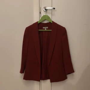 Röd kavaj - Snygg röd kavaj med långärmad design och stilren look. Perfekt för att ge en färgklick till din outfit. Passar bra till både jeans och mer formella byxor.