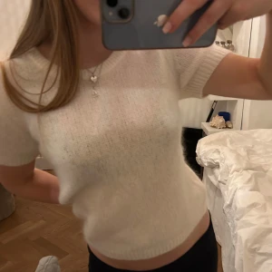 Vit stickad kortärmad topp - Säljer denna superfina och stilrena vita stickade topp med korta ärmar.💞💞Perfekt nu till våren och sommaren! Köpt för 699 och säljer för 399! Aldig använd bara testad 1 gång, har fortfarande prislappen kvar❤️