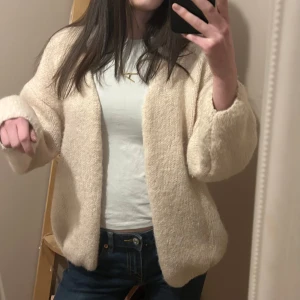 Beige stickad kofta - Mysig, trendig beige stickad cardigan - kofta från Lindex. Perfekt för kyligare dagar och ger en avslappnad look. Aldrig använd med prislappen kvar. Storlek M/L. Byter gärna mot samma kofta i storlek XS/S 💕💕